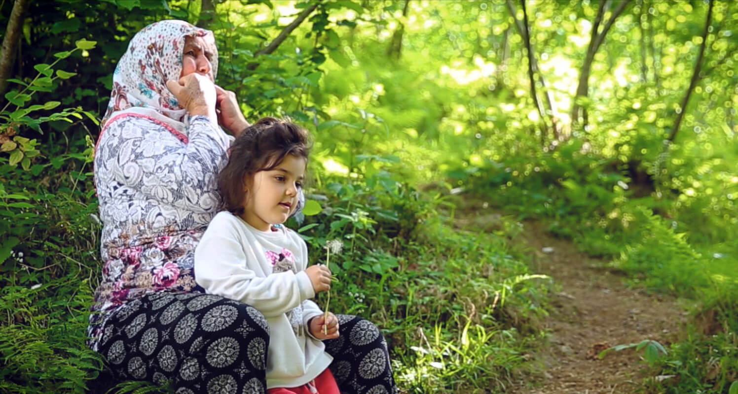 زنی در روستای کوشکوی ترکیه که در حال سوت زدن در کنار کودکی است